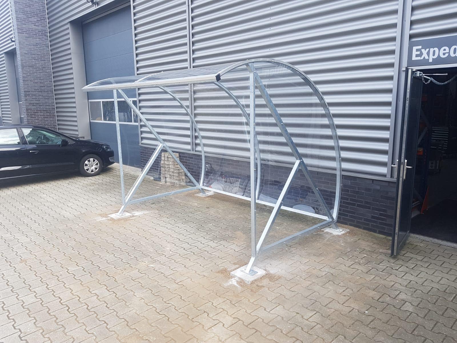 Fietsoverkapping BF1000 - AANBIEDING 13 Onze BF1000 fietsoverkapping in de verzinkte uitvoering, lengte 3 meter geplaatst op betonpoeren 30 x 30cm. Deze overkapping biedt plek voor ca 8 fietsen.