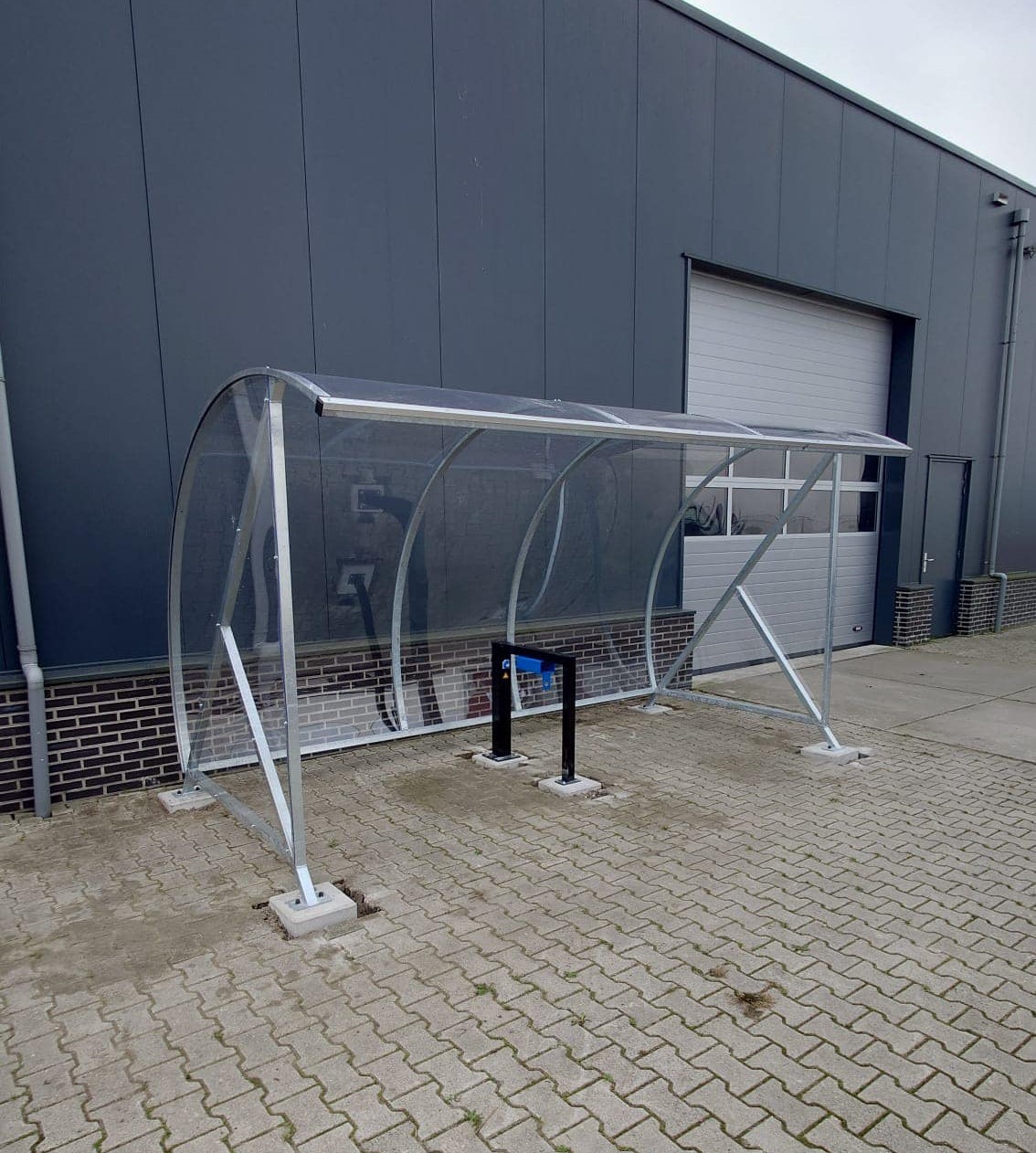 Fietsoverkapping BF1000 - AANBIEDING 37 Fietsoverkapping BF1000 verzinkt met onze aanleunbeugel model Marion met 2 oplaadstations voor elektrische fietsen.