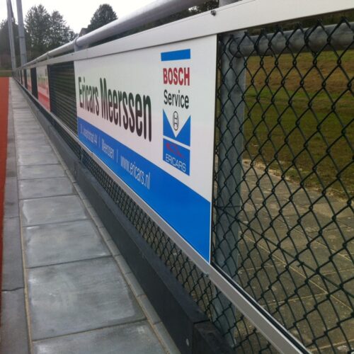 Reclame-ophangsysteem Pro 64 Reclamerails PRO. Hier gemonteerd op gaashekwerk.