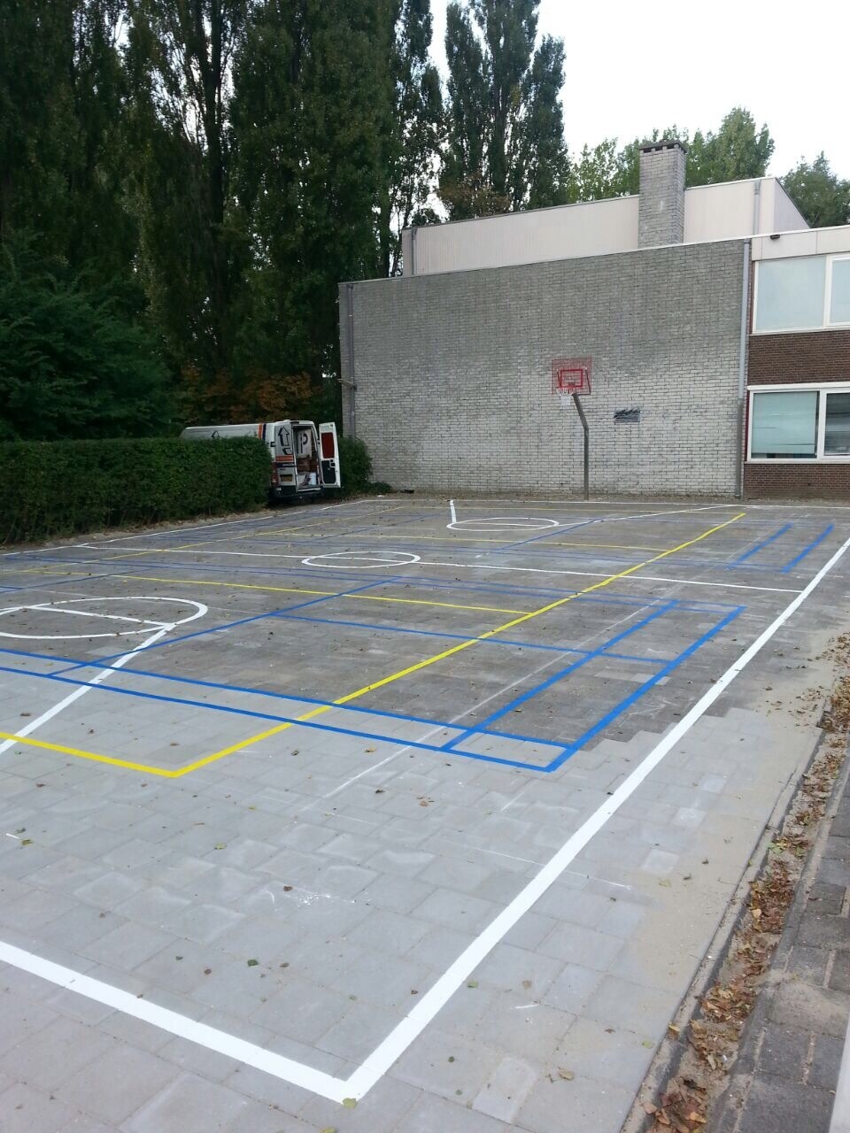 Sportvloercoating 17 Onze rvs basketbalpalen op een door ons belijnd schoolplein in Monnickendam. Basketbal, volleybal en badminton belijningen.