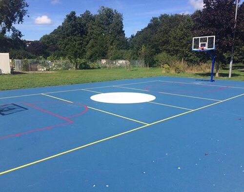 Sportvloercoating 47 Onze basketbalpaal PROFI, op een blauw gecoat basketbalveld met belijning in Leidschendam.