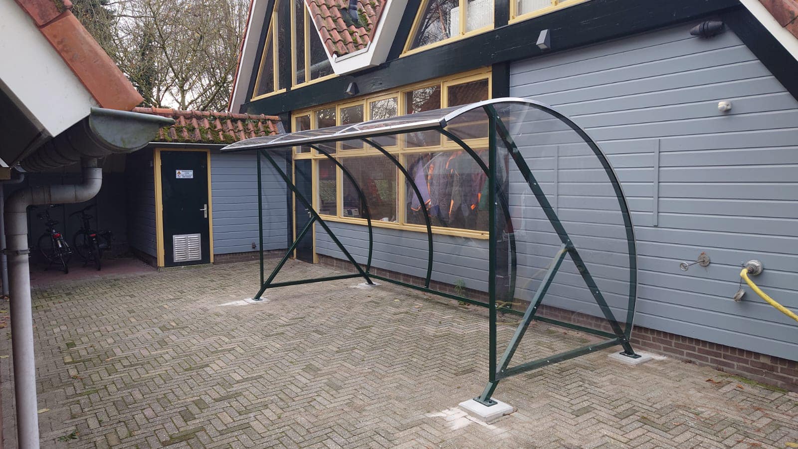 Fietsoverkapping BF1000 - AANBIEDING 7 De 4 meter uitvoering van deze overdekte fietsenstalling c.q. fietsoverkapping in ral 9005 Ideaal voor 10 fietsen. Volledig gemonteerd geleverd, inclusief prefab funderingen 30x30cm.