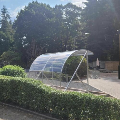 Fietsoverkapping BF1000 - AANBIEDING 100 De BF1000 fietsoverkapping, die is uitgerust met thermisch verzinkt staal en slagvast transparant polycarbonaat, is niet alleen perfect voor fietsenstalling, maar kan ook ingezet worden als rookabri voor groepen van 6 tot 8 personen.