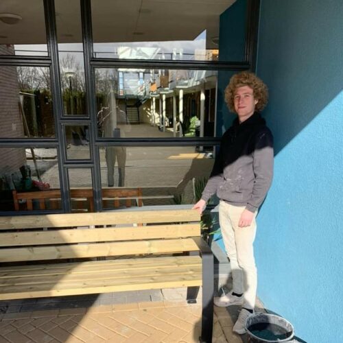 Parkbank Sofia 21 1 van onze monteurs naast de geplaatste parkbank. Naast de levering van uw straatmeubilair, kunnen wij ook de montage voor u verzorgen.