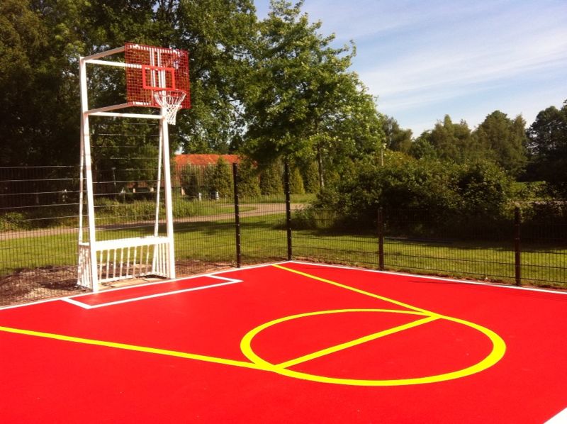 Sportvloercoating 18 Onze pannakooi -basketbal -combinatie. Rood gecoate vloer, voorzien van witte en gele belijningen.