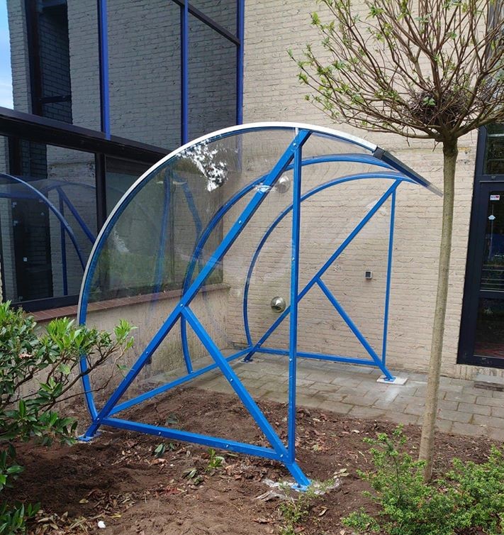 Fietsoverkapping BF1000 - AANBIEDING 16 Onze BF1000, hier uitgevoerd in een frisse blauwe ral kleur. Ideaal als rook abri en fietsoverkapping. Een elegante en zeer duurzame oplossing.