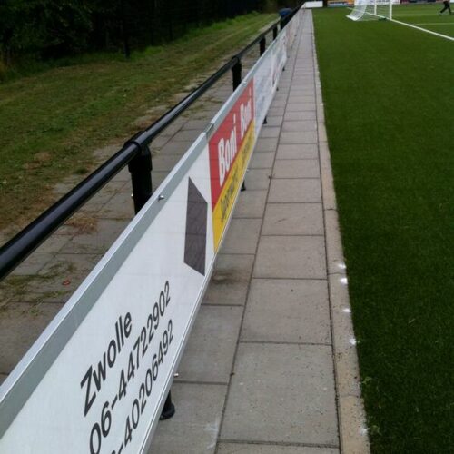 Reclame-ophangsysteem Pro 63 Hier is het reclamebord ophangsysteem op een standaard leun-hekwerk gemonteerd