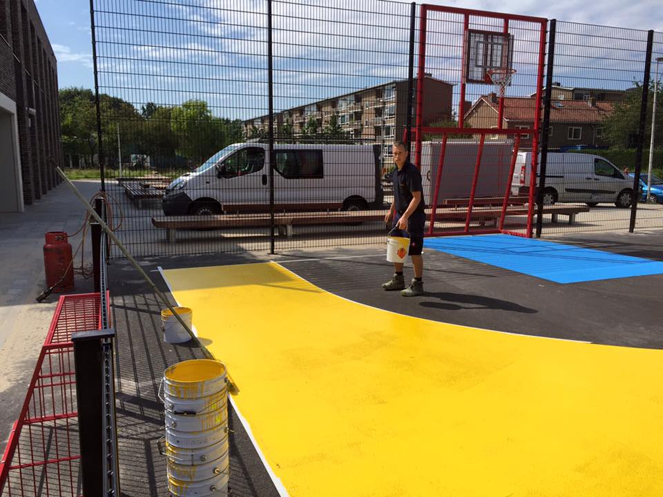 Sportvloercoating 7 Werkzaamheden grote voetbalkooi, sportkooi in Rotsoord Utrecht. Op de afbeelding ziet u het aanbrengen van de Granuplast rolcoating. .