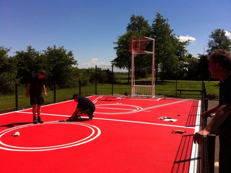 Sportvloercoating 2 Pannakooi met basketbal. Coating van sport en spelvloeren. De mogelijkheden zijn legio. Afgebeeld de werkzaamheden bij de door ons geplaatste mini multi-sportkooi in de gemeente Slochteren.