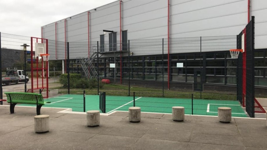 Sportvloercoating 3 Onze Premium voetbalkooi met basketbal, voorzien van een groene Granuplast rolcoating en witte belijningen.