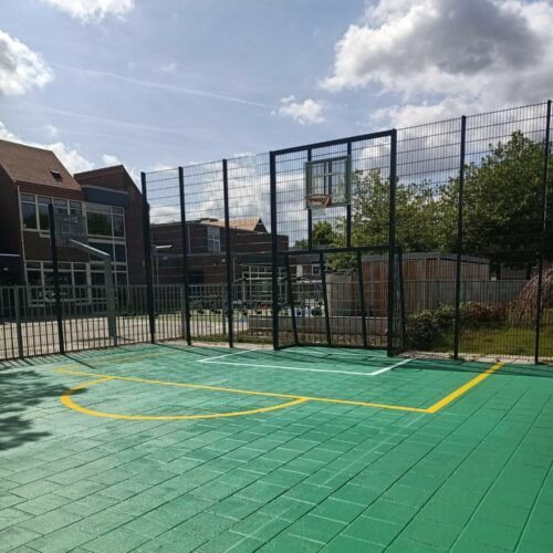 Sportvloercoating 71 Sportkooi Heerlen met een groene Granuplast rolcoating en gele en witte sportbelijningen.