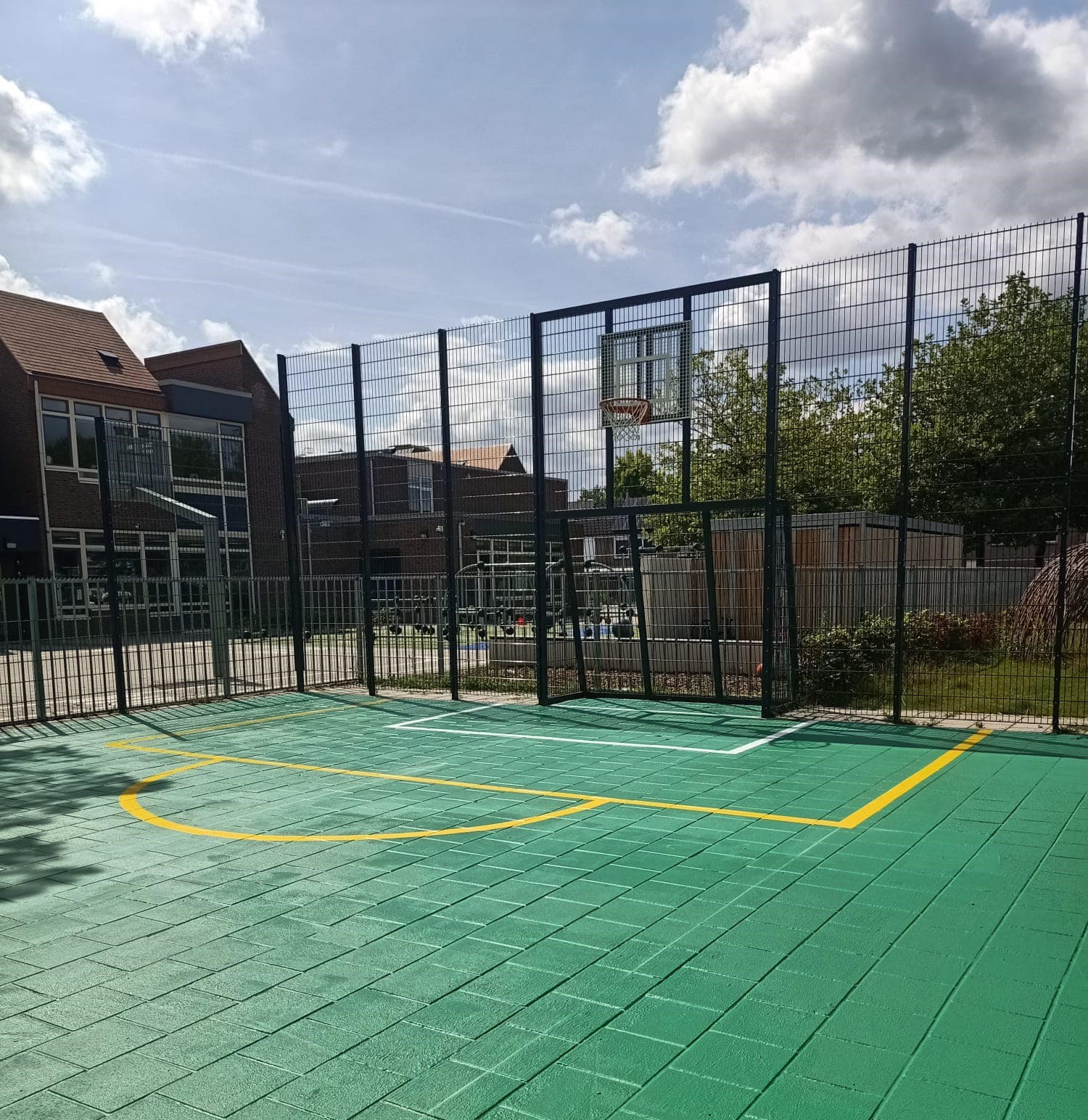 Sportvloercoating 34 Sportkooi Heerlen met een groene Granuplast rolcoating en gele en witte sportbelijningen.